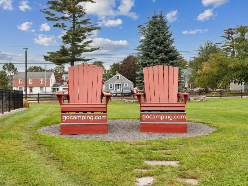 Two oversized Adirondack chairs in a field